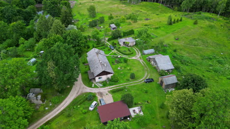 casa de granja rural al final de un camino de tierra en el campo verde exuberante, aérea