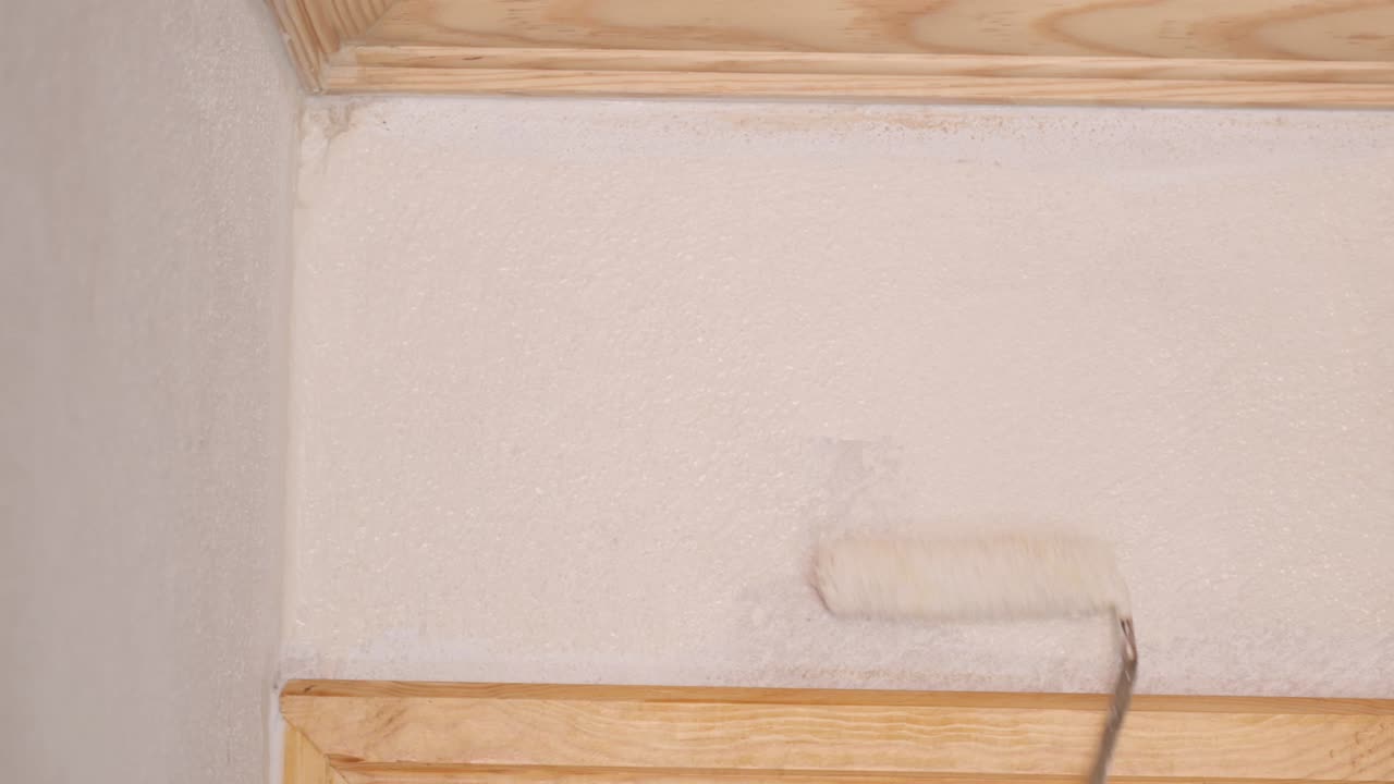 Painting a wall corner with a paint roller