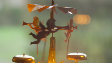primer plano de un ángel de navidad de bronce con velas