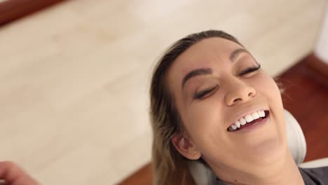 mujer alegre durante la sesión de maquillaje