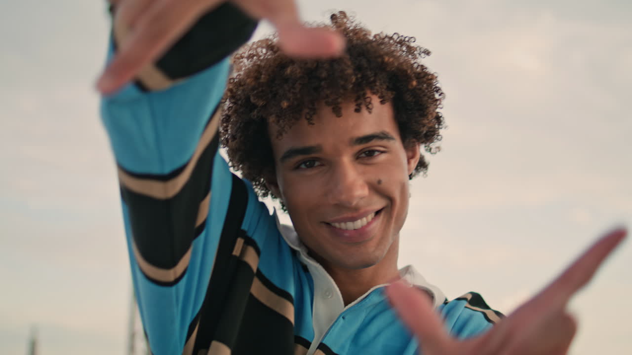 las manos positivas de los estudiantes gesticulando retrato callejero. modelo rizado fotografiando brazos