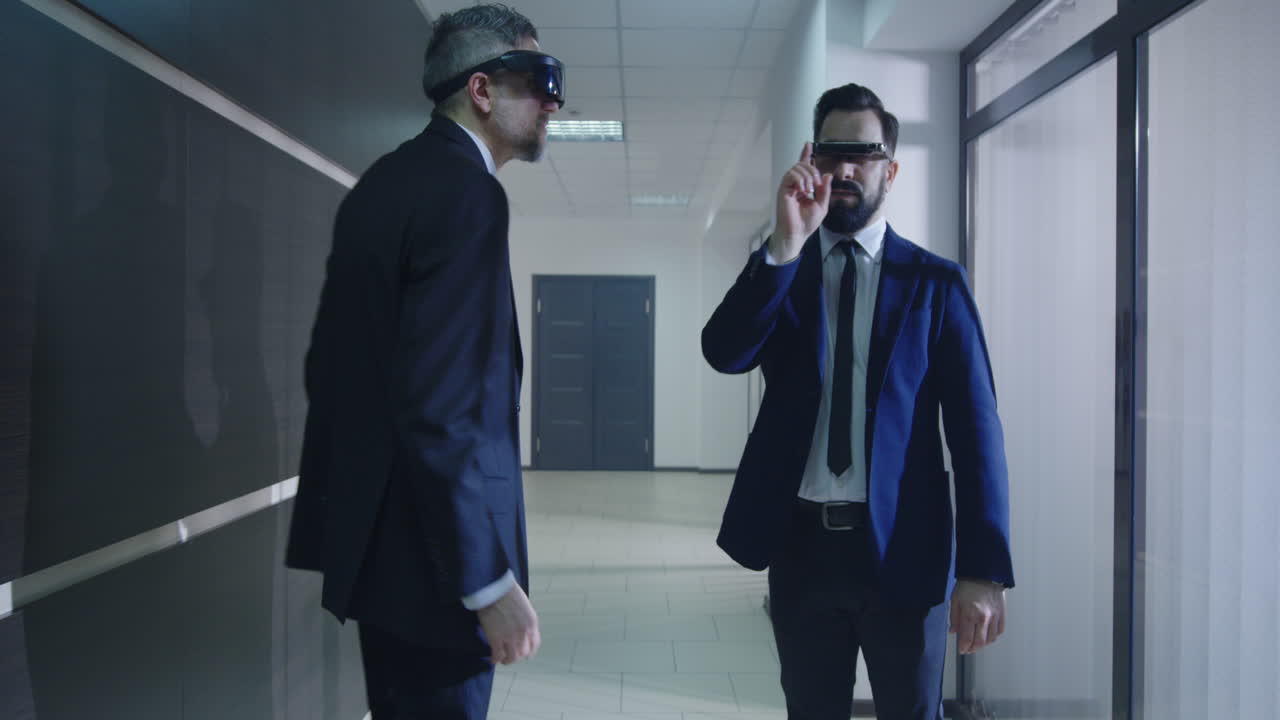 Businessmen Using VR Glasses in Office Corridor. Medium shot of businessmen using VR glasses and walking in office corridor