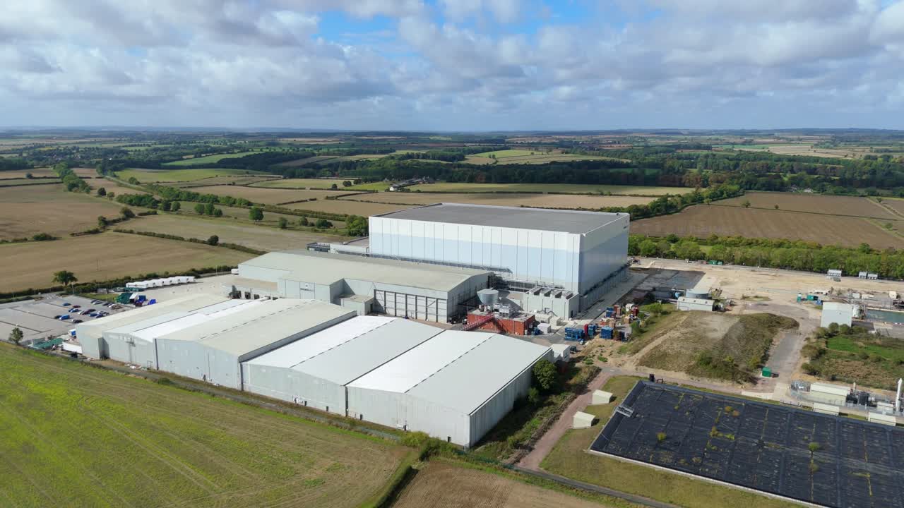 Cinematic aerial shot of industrial cold storage site with large warehouses and rural landscape near Grantham, England
