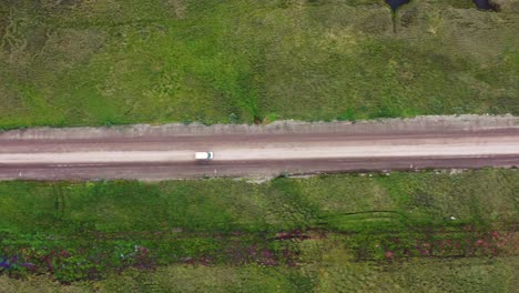 viaje en coche o furgoneta conduciendo por un camino de tierra a través de los terrenos salvajes de alaska - vista aérea de arriba hacia abajo siguiendo