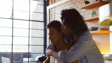 woman hugging from behind while man using laptop 4k