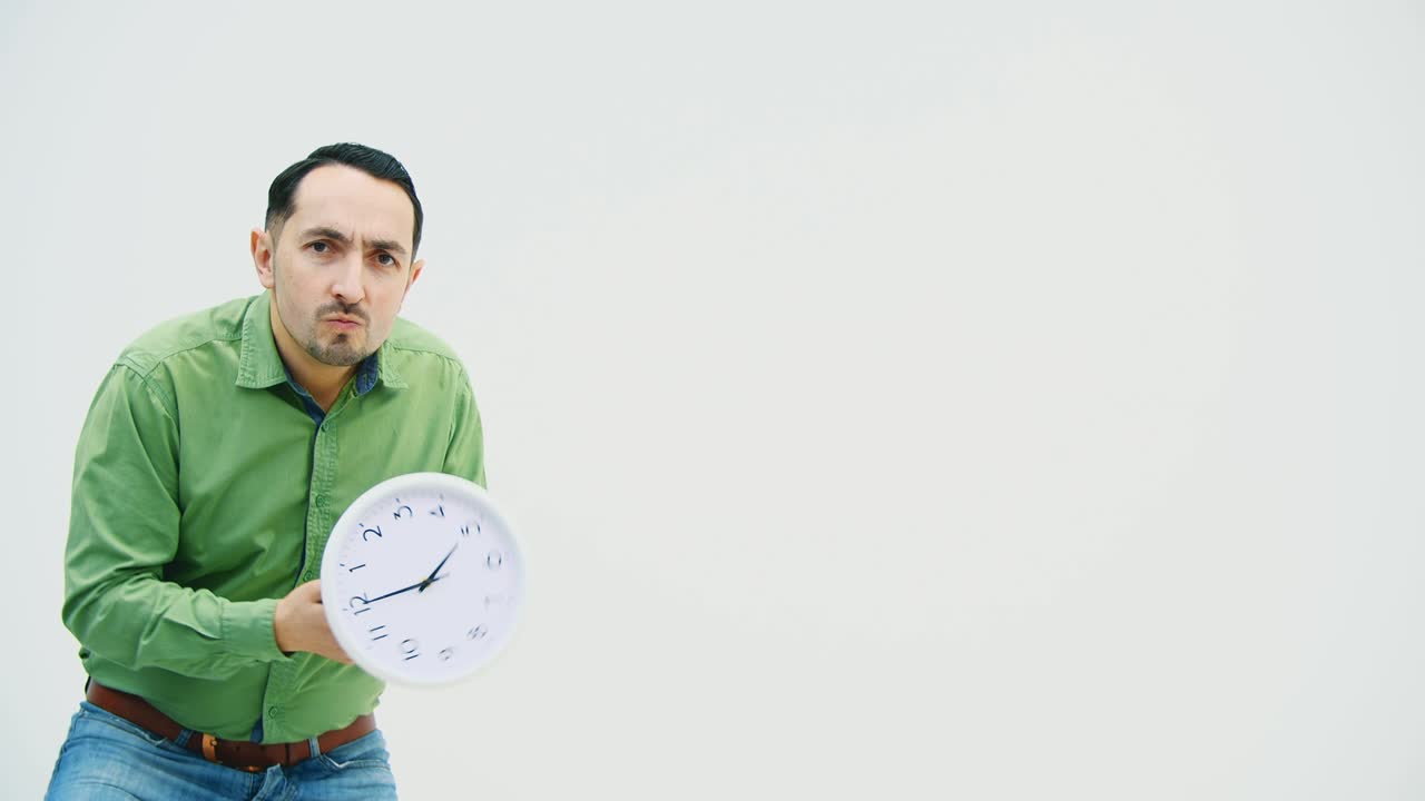 um jovem cômico de roupas casuais está brincando, dando voltas ao relógio nas mãos, dançando tolamente, depois indo-se embora, acenando para se despedir.