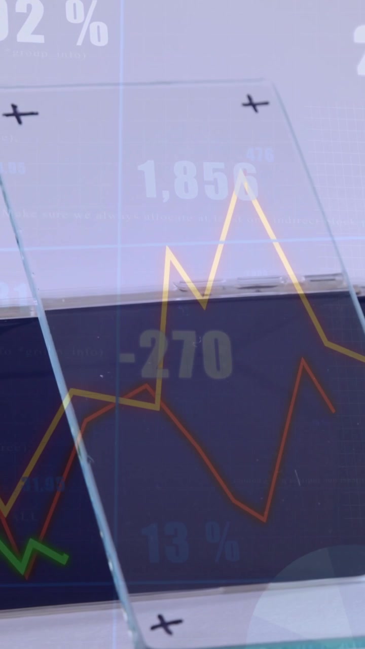 Vertical video: With gold line appearing behind glass, charts climbing and showing market trends