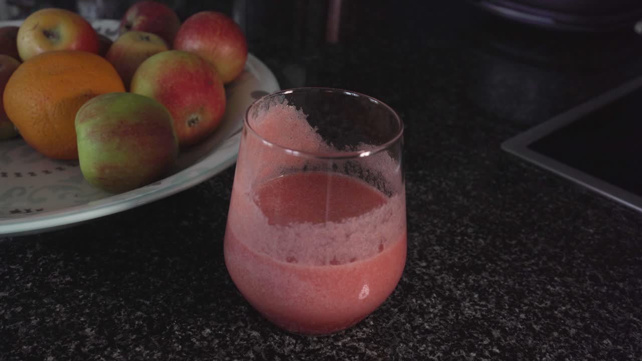 Filmato di un frullato in un bicchiere e un piatto di frutta
