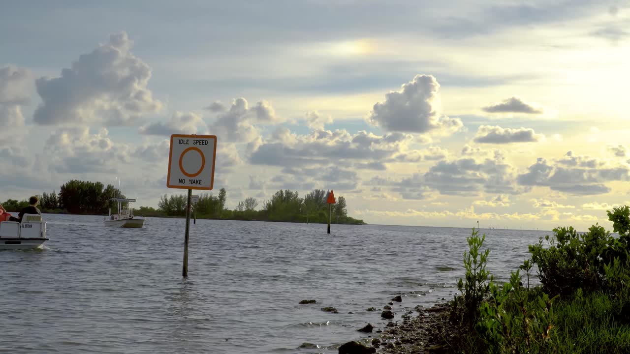 Tourist boats off the Florida gulf coast shoreline pass the channel