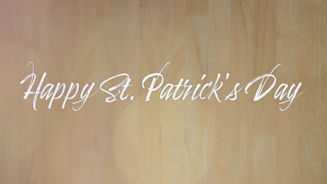 Text animation of happy saint patrick's day over wooden background