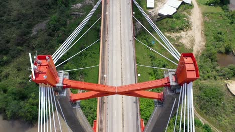 Drone-vertical-view-of-vehicles-crossing-Paraná-river-through-Zarate-bridge-in-Buenos-Aires,-Argentina