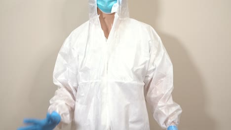 female doctor in ppe suit making a heart gesture with her fingers