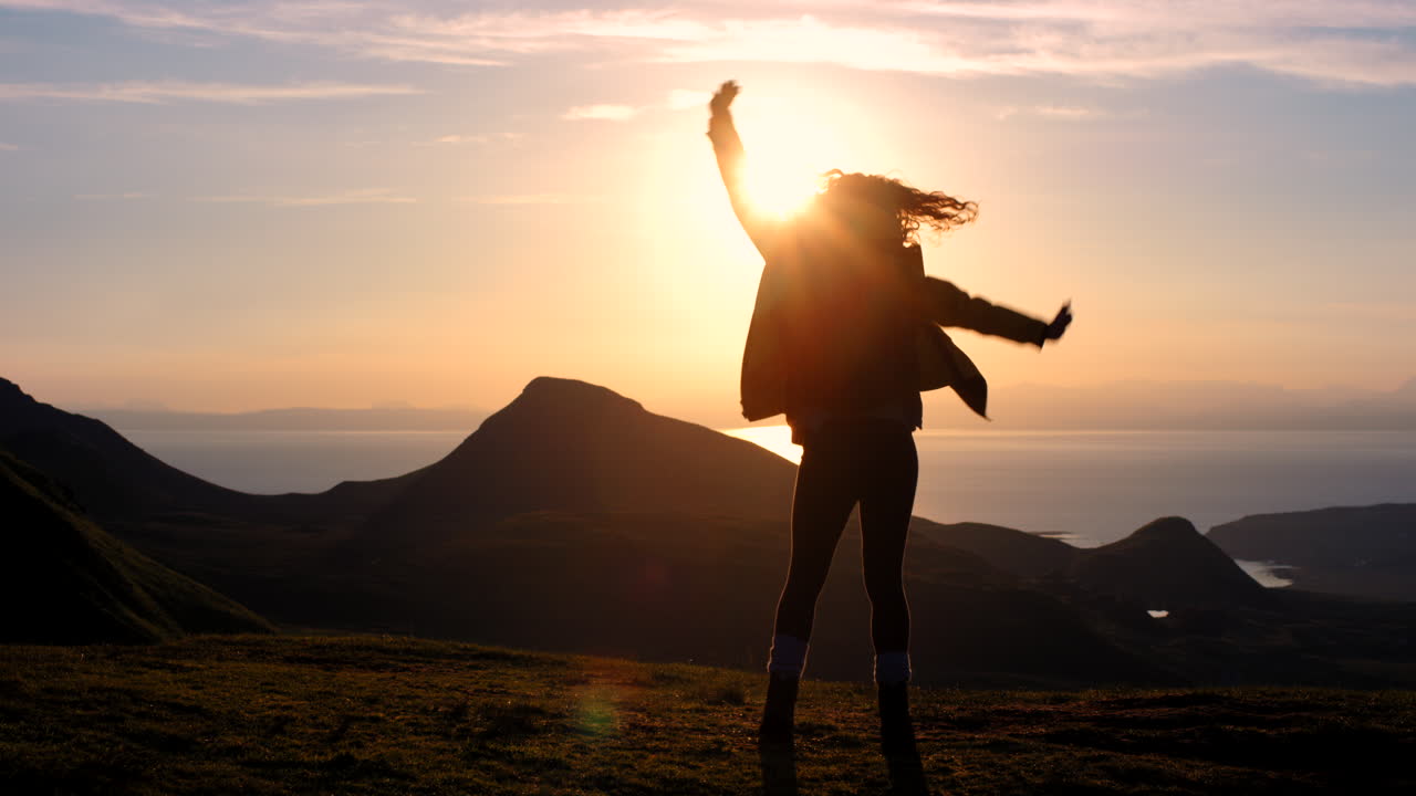 Donna che balla al tramonto sulle montagne