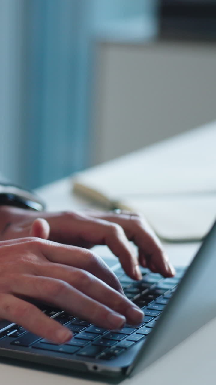 Nahaufnahme von Händen, die auf einer Laptop-Tastatur tippen