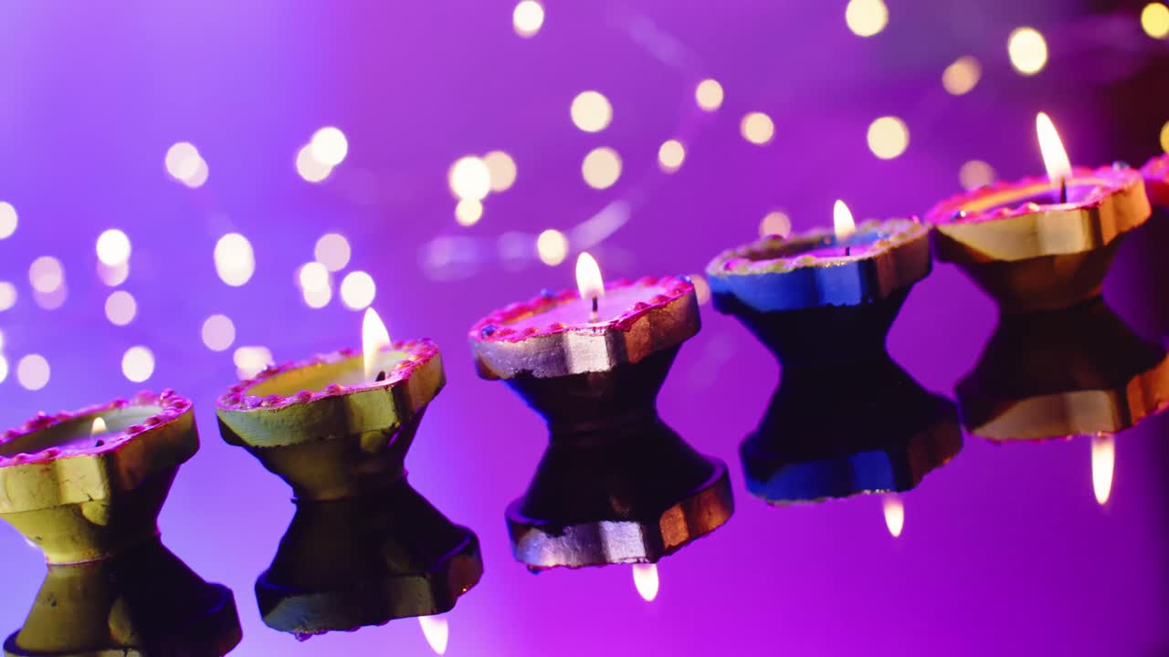 cerca de las luces y la quema de velas de colores celebrando diwali sobre un fondo púrpura