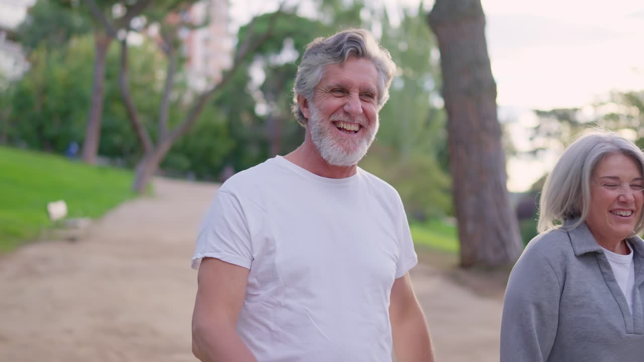 Feliz pareja de ancianos abrazándose y caminando juntos en un parque