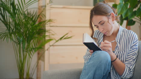 mujer reflexiva tomando notas