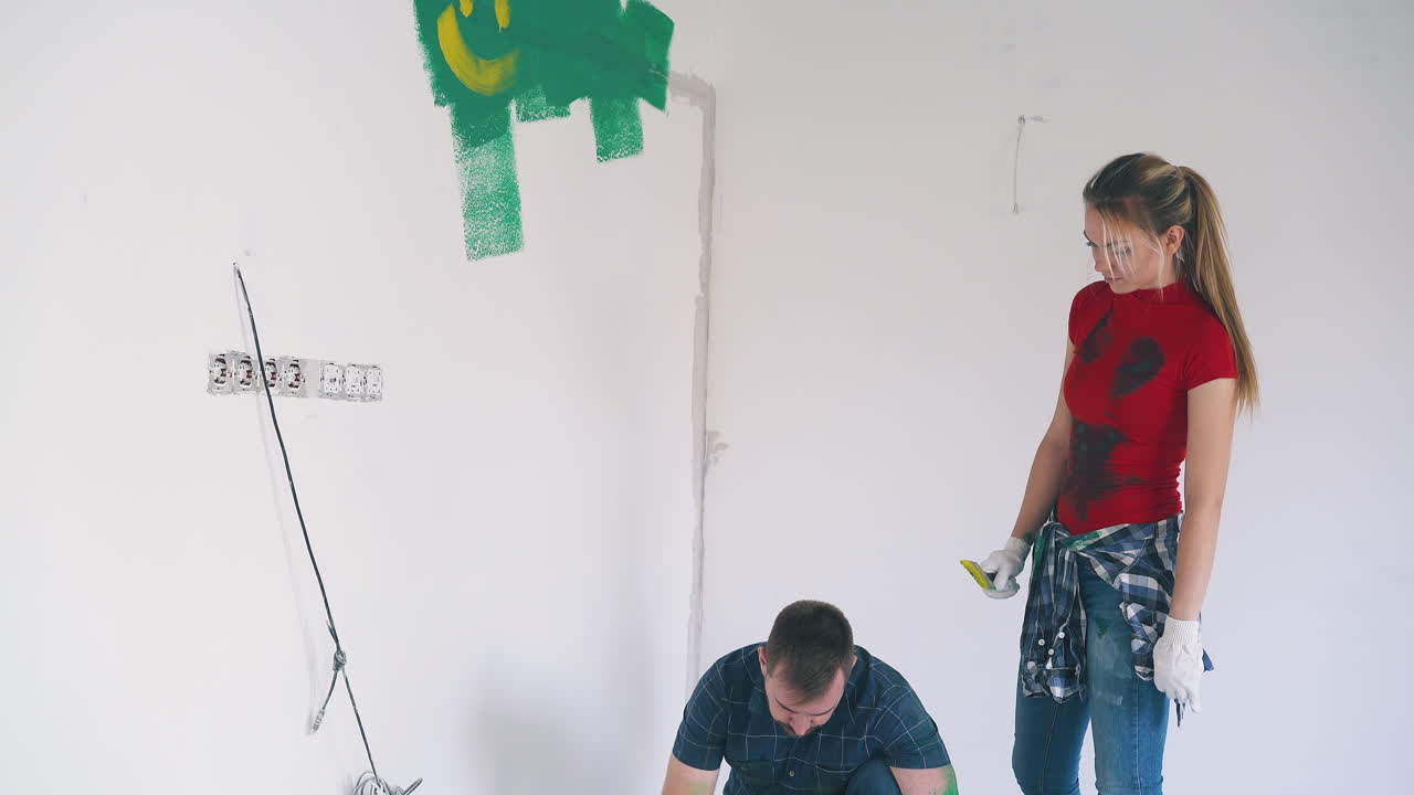 페인트 스트로크를 가진 소녀는 빈 방에서 남자친구  ⁇ 에 서 있습니다.