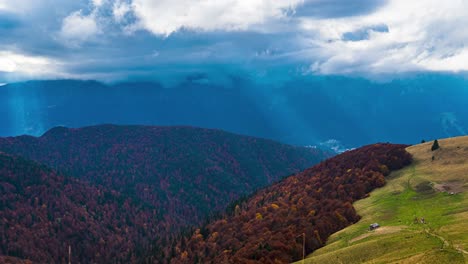 Paisaje-De-Montaña-Otoñal-Con-Colores-Vivos-Y-Rayos-De-Sol-Que-Estallan-A-Través-De-Las-Nubes-Lluviosas-Y-Arremolinadas