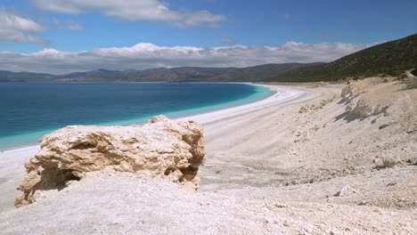 panoramic view to turkish hills over deserted white beach and turquoise lake