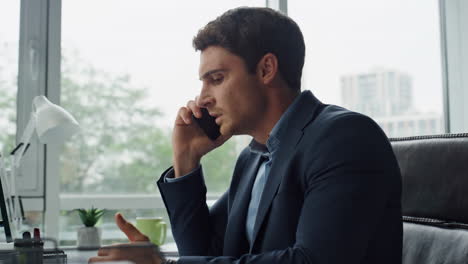 mad businessman talk phone in office closeup. angry man customer complain bank