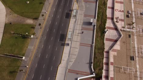 Top-down-ansicht-Eines-Mannes,-Der-An-Einem-Sonnigen-Tag-In-Einem-Natürlichen-Hintergrund-Neben-Der-Straße-Von-Fahrzeugen-Auf-Der-Straße-Von-Mar-Del-Plata-In-Argentinien-Läuft