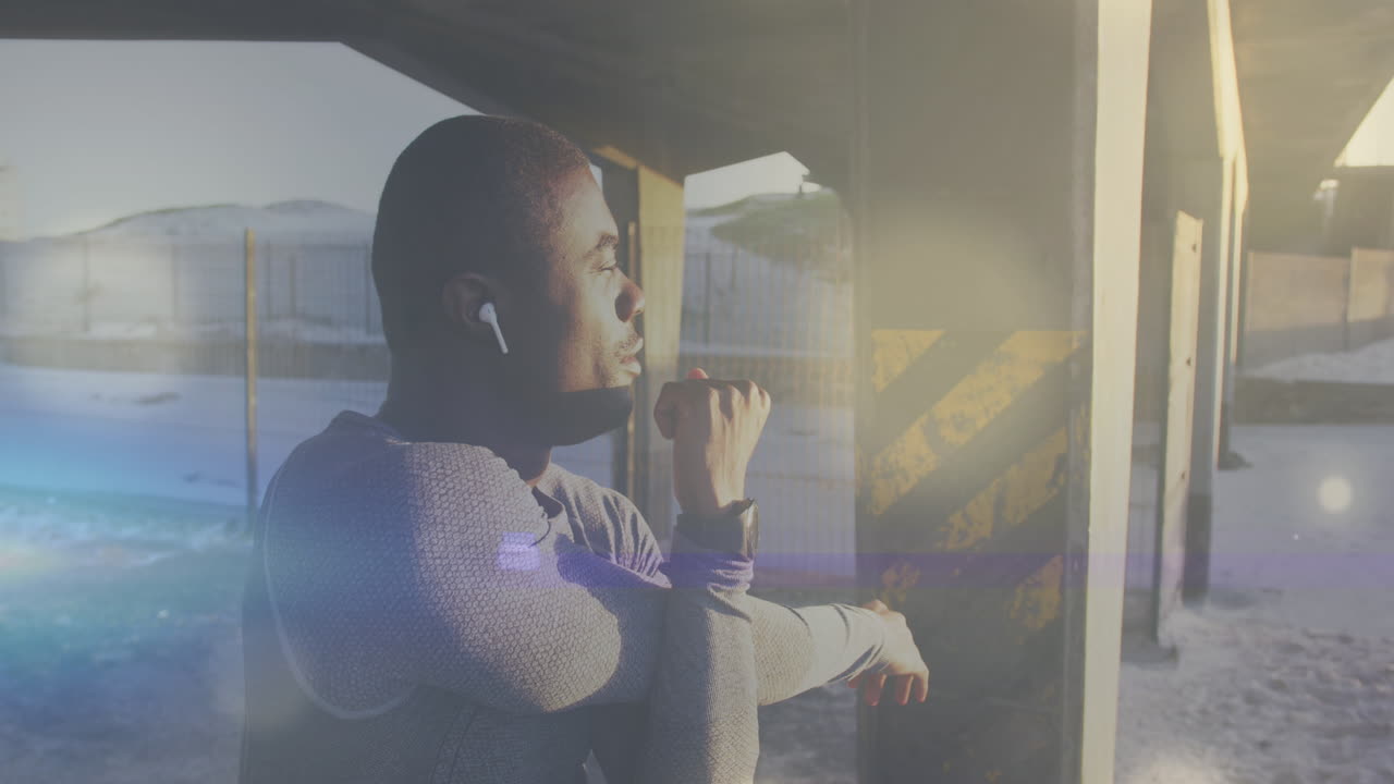 Animation of light spots over african american man stretching outdoors