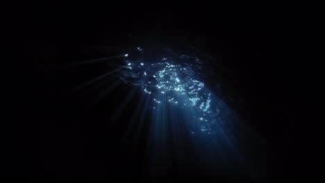 rayos de luz penetrando bajo el agua por la noche