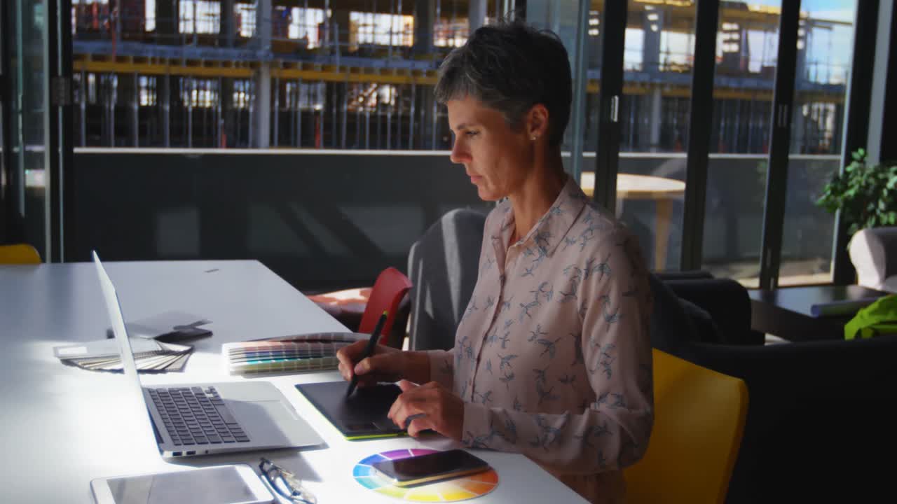 graphic designer femminile che usa il tablet grafico alla scrivania 4k