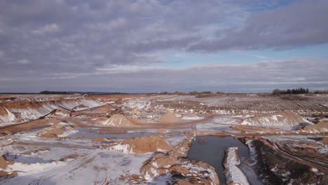 drone flyover open mining pit, mining machines, gravel pit in europe - dolly in shot