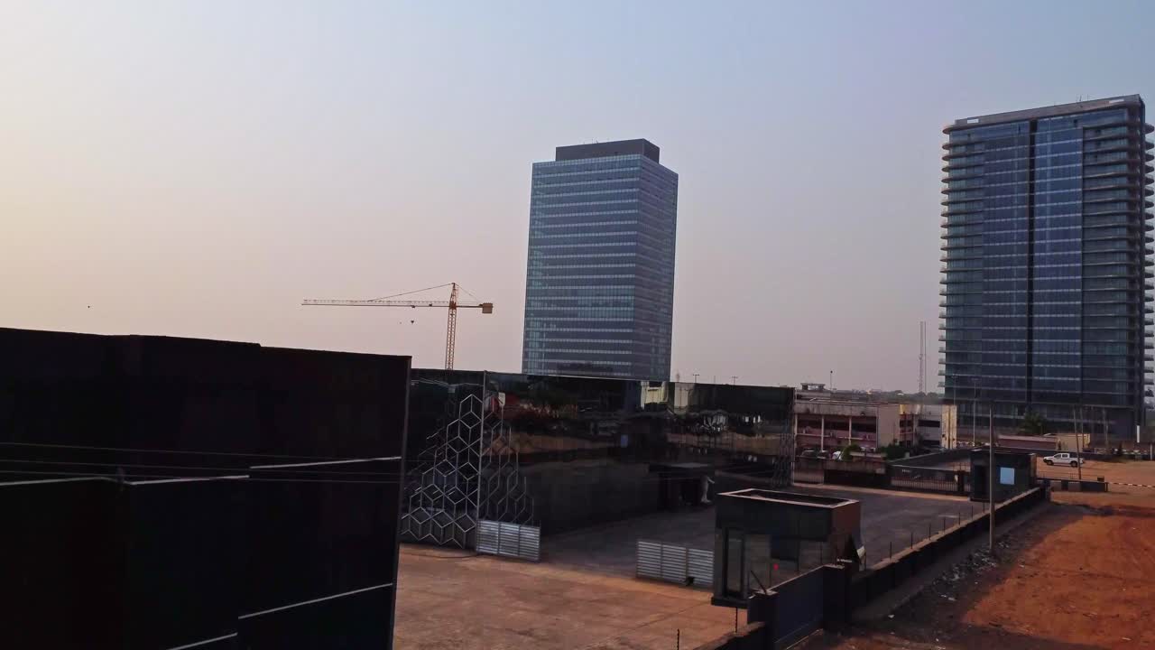 Jib up of a modern business district in Abuja, Nigeria at sunset