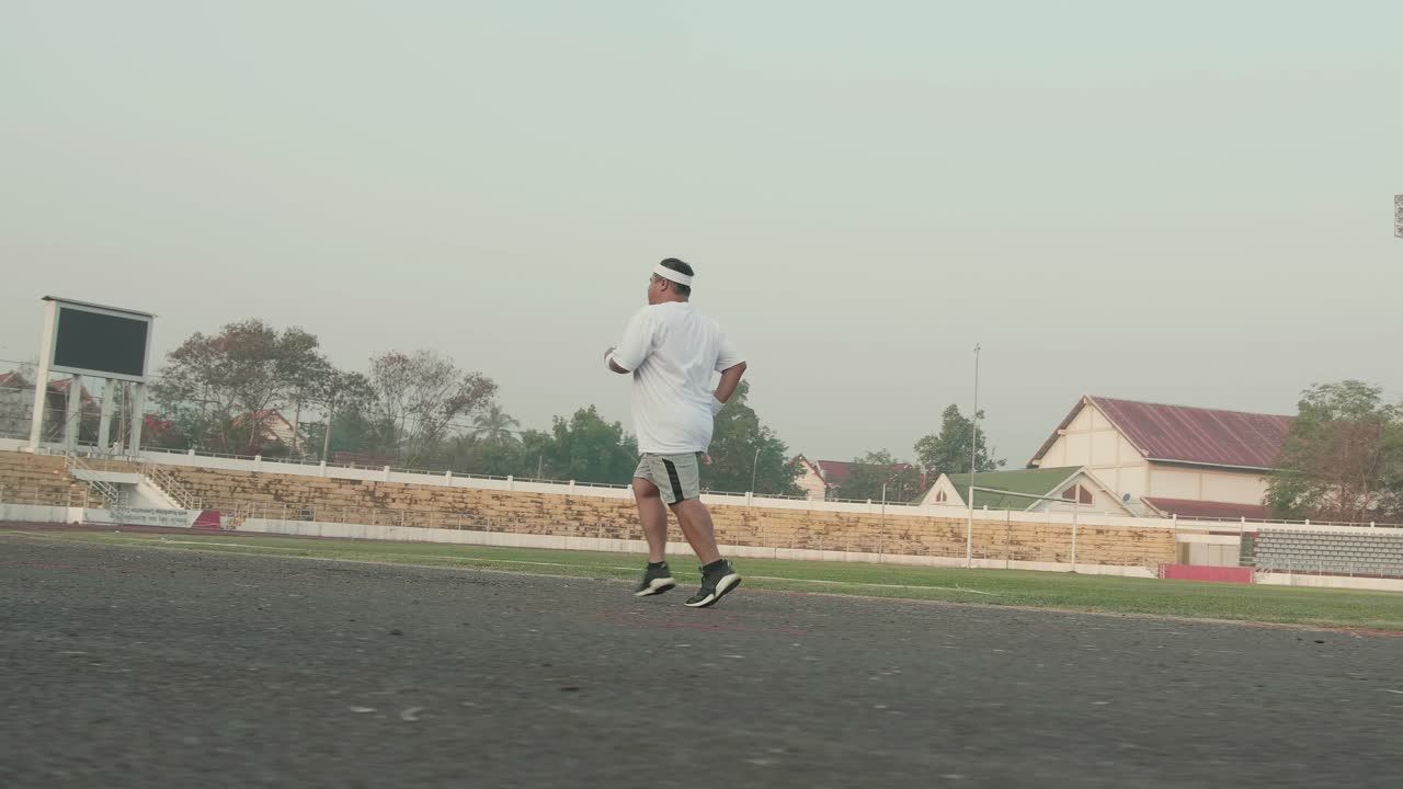 Fat Man Jogging For Exercising At Stadium
