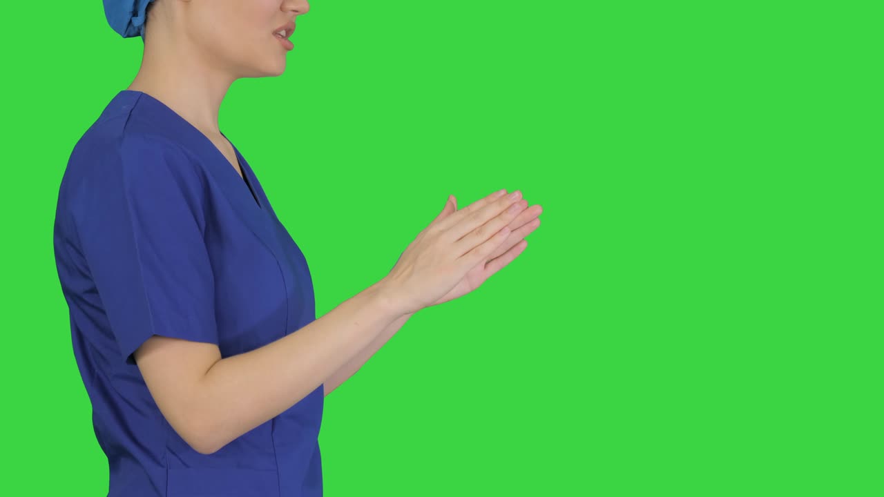 푸른 유니폼을 입은 여성 의사가 녹색 스크린, 크로마 키에서 의료에 대해 이야기합니다.