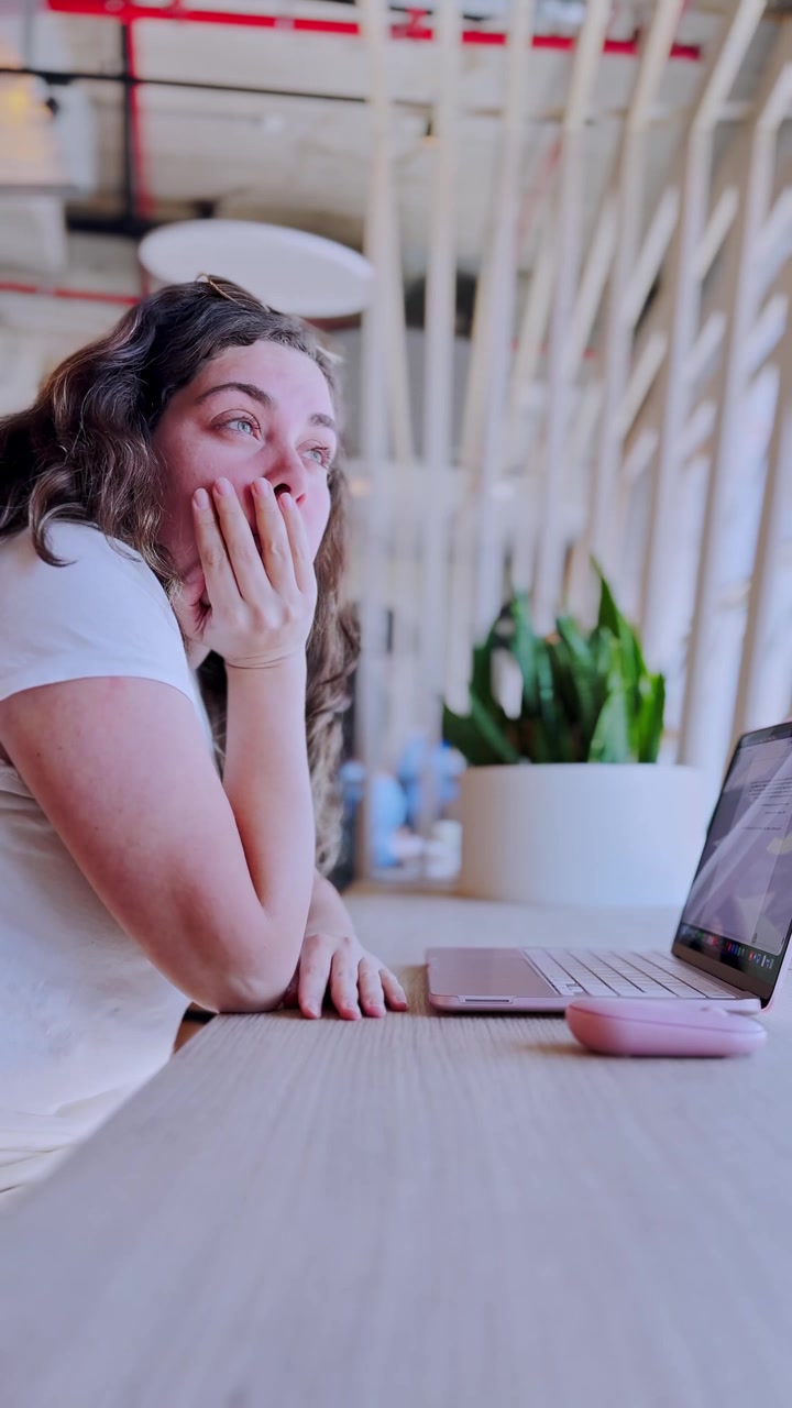 Donna freelancer stanca che sbadiglia mentre lavora al laptop