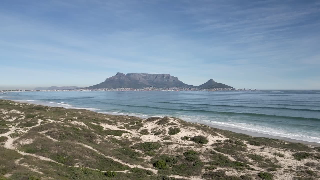 Drone shot over Blouberg Beach to reveal Table Mountain in the distance
