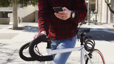 Albino-african-american-man-with-bike-using-smartphone