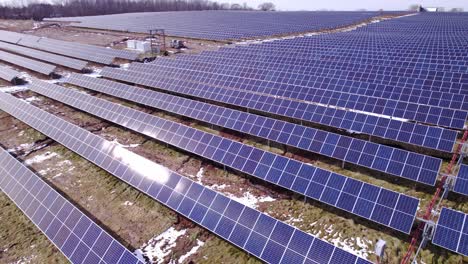 Rows-of-solar-panels-at-power-station-in-Michigan,-aerial-parallax