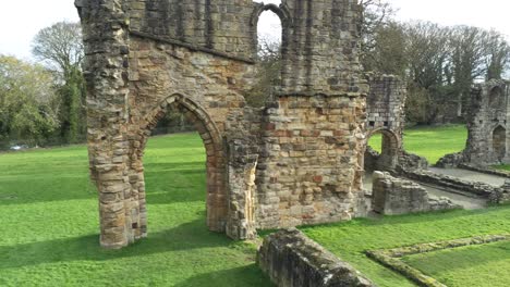 basingwerk abbey landmark medieval abandoned welsh ruins aerial view close orbiting right pull back