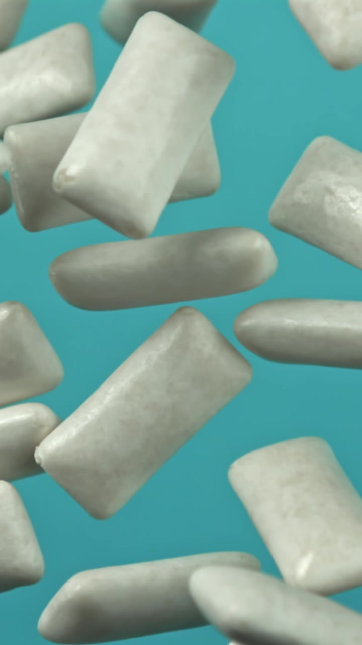 Pezzi di gomma da masticare bianca che galleggiano su uno sfondo blu.