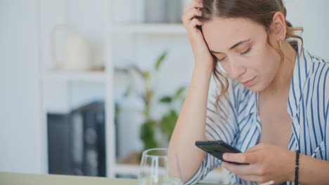 mujer triste navegando por el teléfono inteligente
