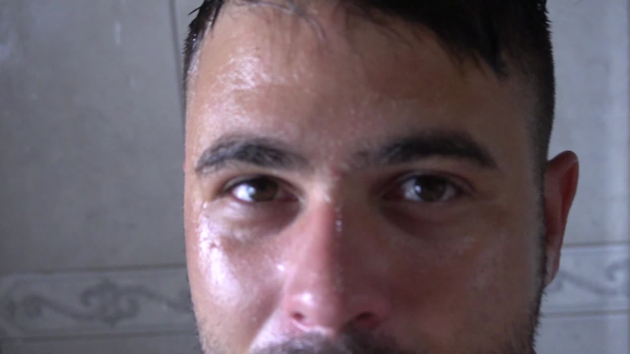 얼굴 관리 루틴 동안 샤워를 하며 즐거운 시간을 보내는 행복한 남자