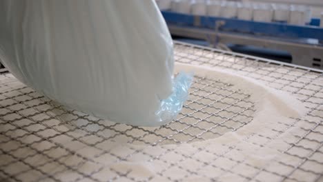 la bolsa de polvo blanco se coloca en la máquina en una fábrica moderna y limpia