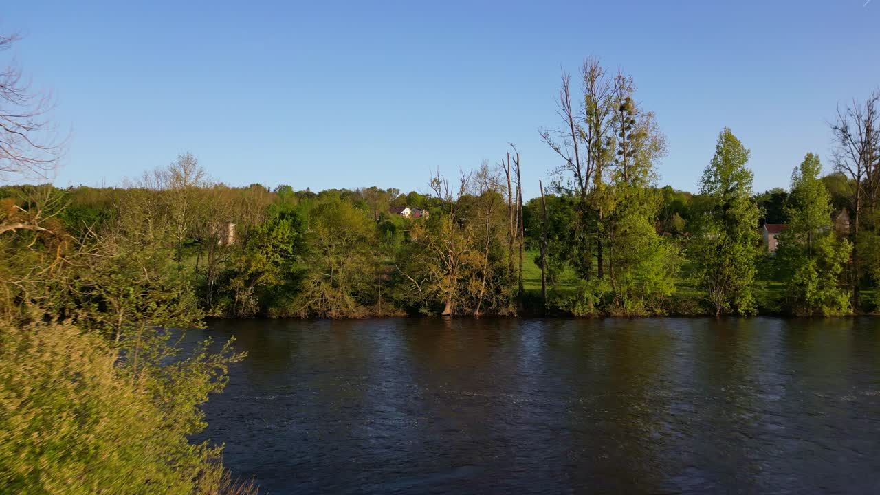 drone volando a baja altitud sobre el río viena en el campo de saint-victurnien al atardecer, nouvelle-aquitaine en francia