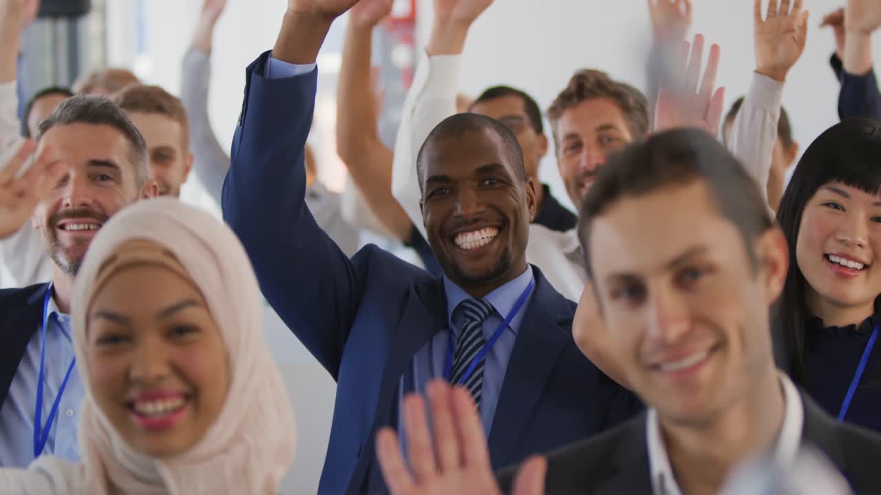 Audience at a seminar raising hands to ask questions