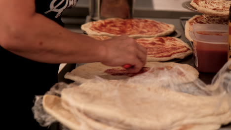 chef prepares several margarita pizzas for customers at music festival