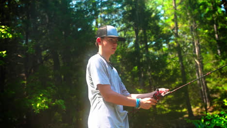 a young man fishing on a sunny afternoon in the woods