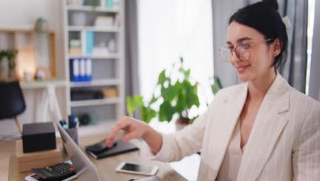 Businesswoman-Opens-Laptop-and-Starts-Working-in-Office