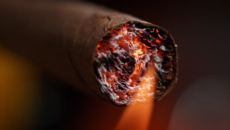 lighting a cigar with fire in slow motion, smoke causing cancer is inhaled, tobacco leaves burn to ashes in macro