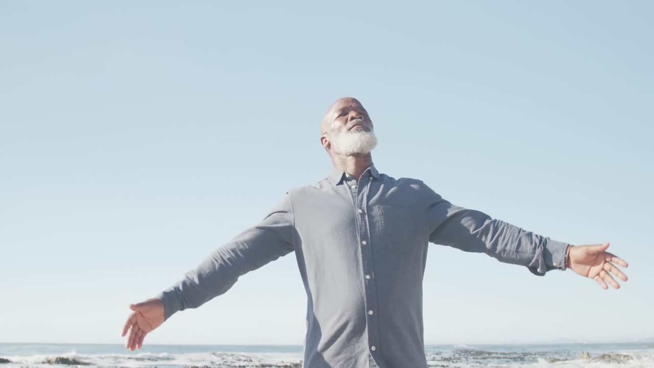 시니어 아프리카계 미국인 남자가 해변에서 팔을 넓히고, 슬로우 모션