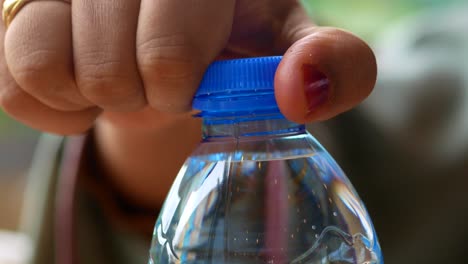 woman unscrewing a blue water bottle